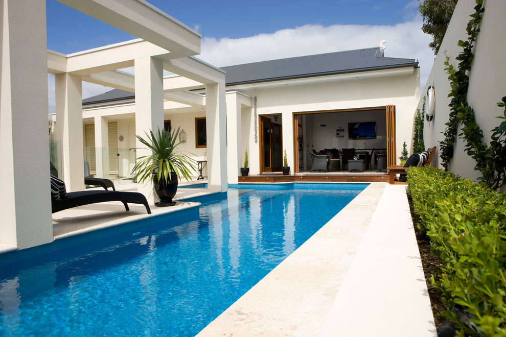 Immagine di una piscina monocorsia design rettangolare di medie dimensioni e dietro casa