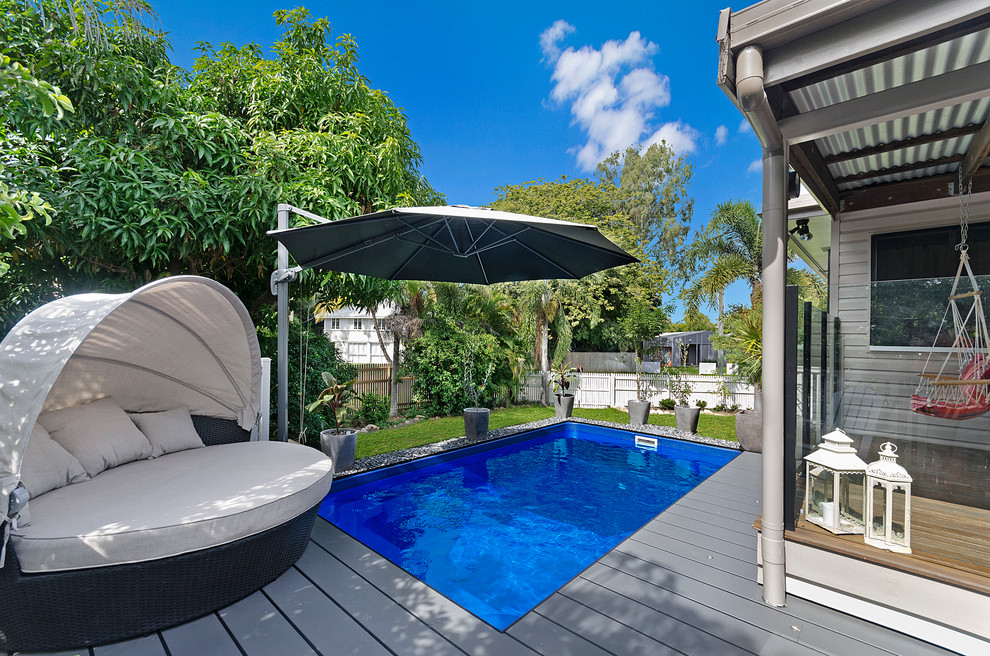 Cette image montre une piscine arrière marine rectangle avec une terrasse en bois.