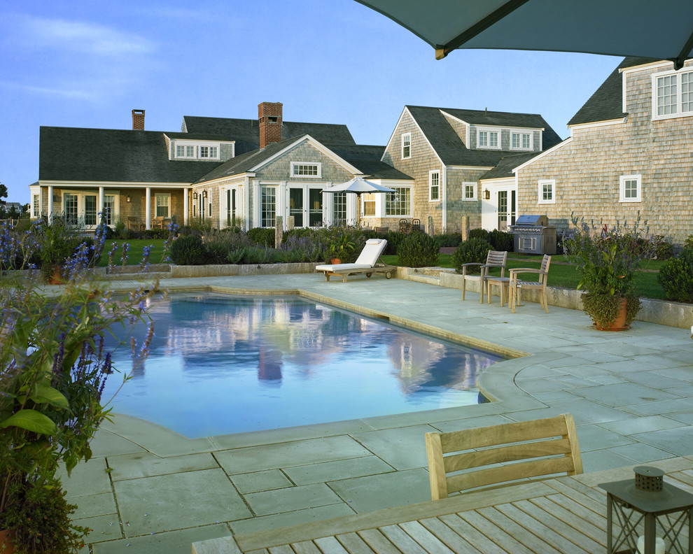 Foto de piscina de estilo de casa de campo grande rectangular en patio trasero con adoquines de piedra natural