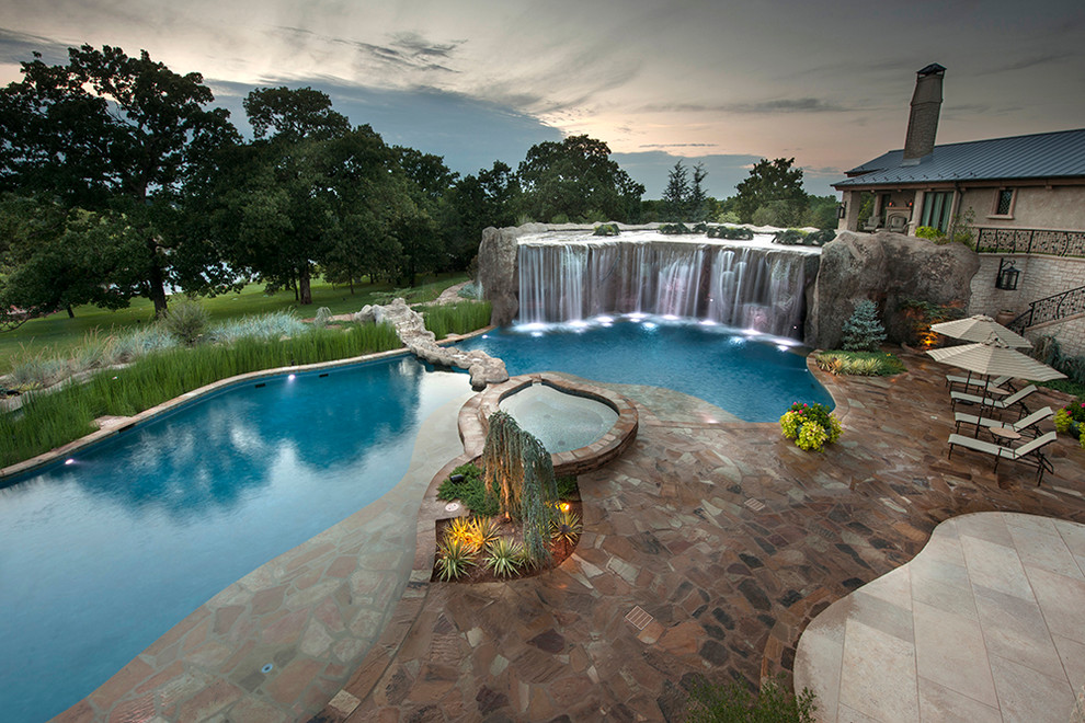 Imagen de piscina con fuente natural ecléctica extra grande a medida en patio trasero con adoquines de piedra natural