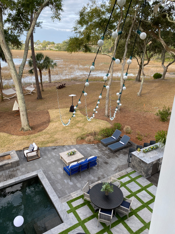 Foto di un'ampia piscina naturale costiera rettangolare dietro casa con pavimentazioni in mattoni