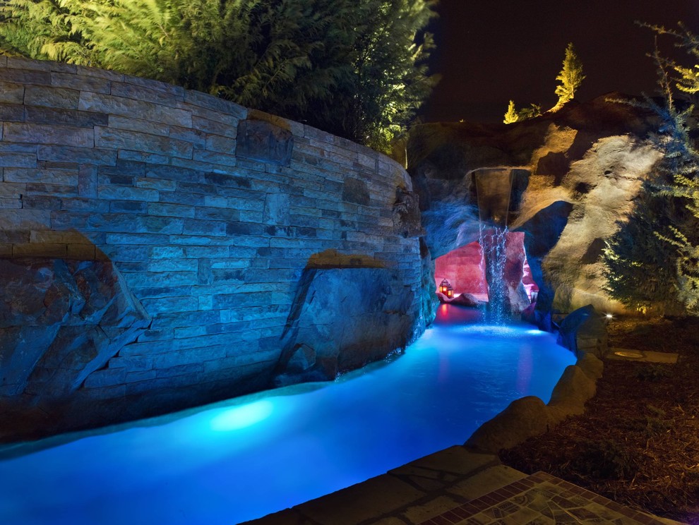 Пример оригинального дизайна: огромный естественный бассейн в стиле рустика с фонтаном