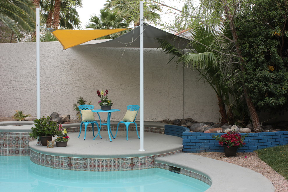 На фото: бассейн среднего размера, произвольной формы на заднем дворе в стиле ретро с покрытием из бетонных плит