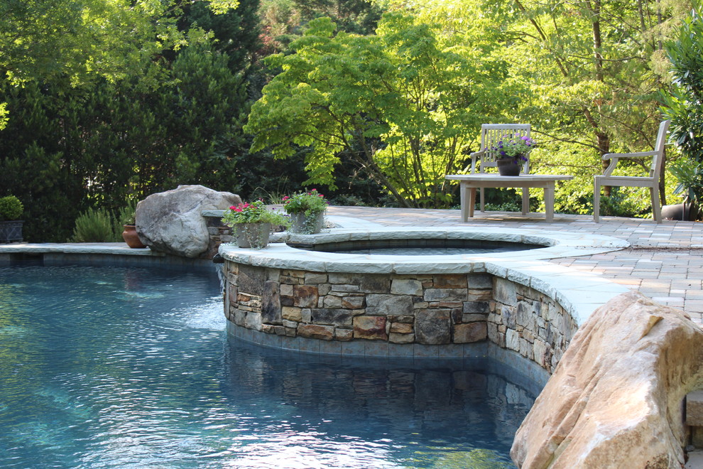 Exemple d'une piscine chic avec des pavés en pierre naturelle.