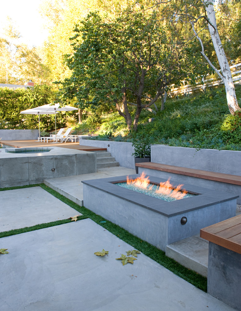 Foto de piscinas y jacuzzis tradicionales renovados grandes a medida en patio trasero con losas de hormigón