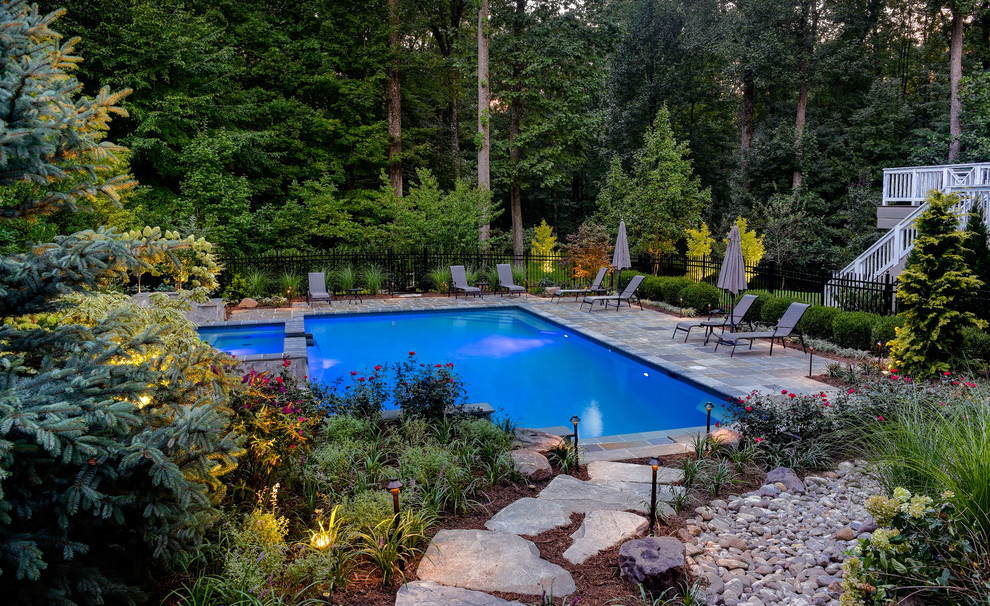 Photo of a traditional back custom shaped lengths swimming pool in DC Metro with natural stone paving.