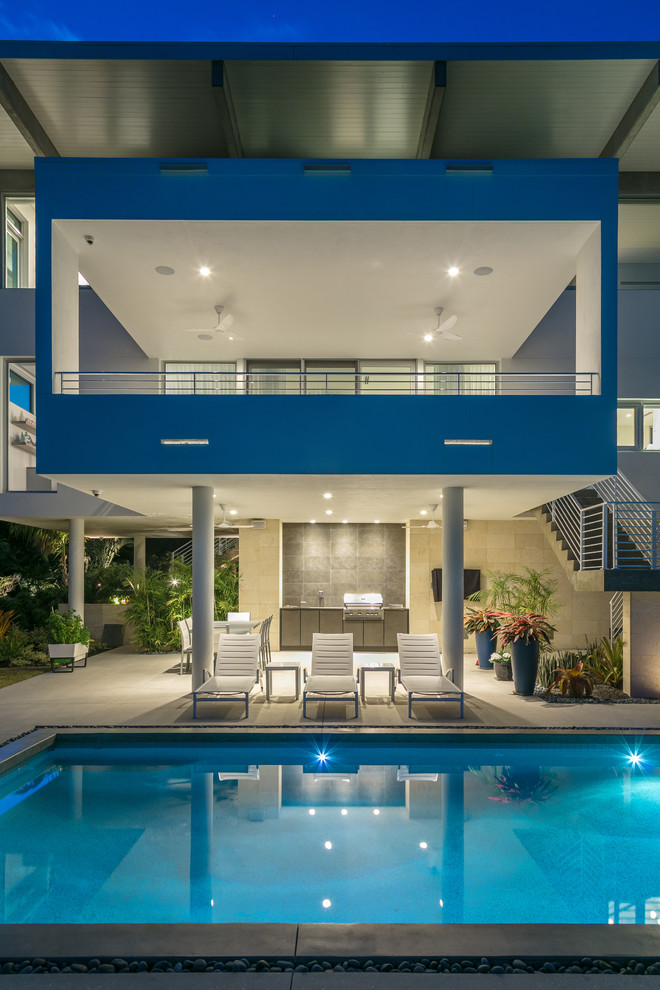 Foto di una grande piscina design rettangolare dietro casa con pavimentazioni in cemento