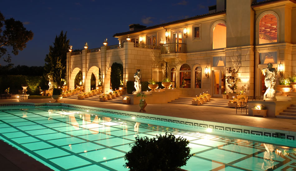 Immagine di una grande piscina monocorsia mediterranea rettangolare dietro casa con piastrelle