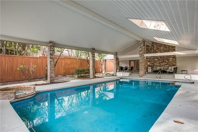 Пример оригинального дизайна: большой естественный бассейн в доме в стиле неоклассика (современная классика) с домиком у бассейна