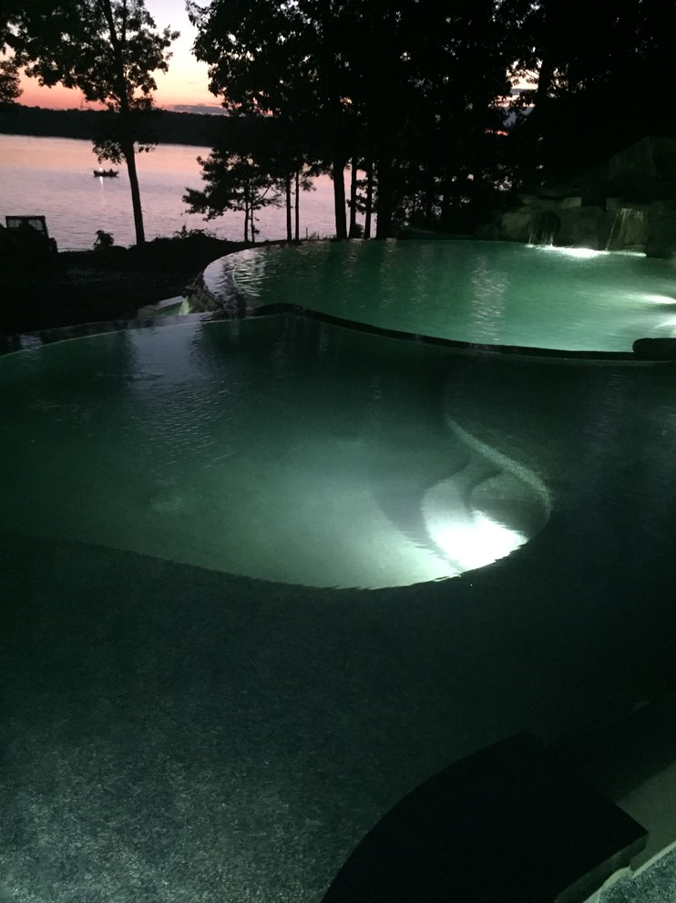 Foto di una grande piscina a sfioro infinito contemporanea personalizzata dietro casa con un acquascivolo