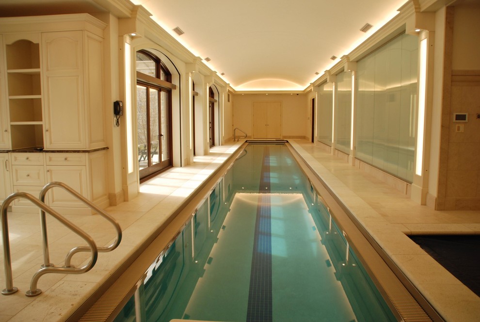 Foto di un'ampia piscina monocorsia minimalista rettangolare con una vasca idromassaggio e pavimentazioni in pietra naturale