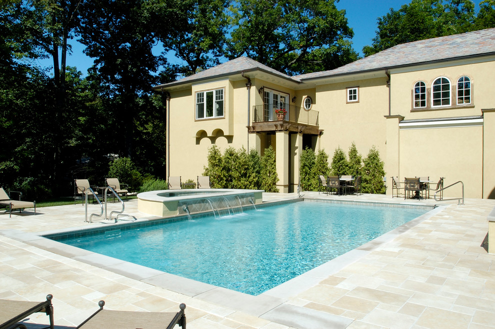 Idee per una piscina monocorsia mediterranea rettangolare di medie dimensioni e in cortile con una vasca idromassaggio e pavimentazioni in pietra naturale