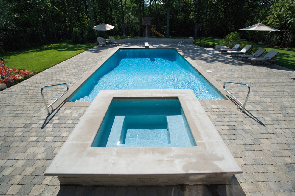 Foto di una piscina monocorsia tradizionale rettangolare di medie dimensioni e dietro casa con pavimentazioni in cemento e una vasca idromassaggio