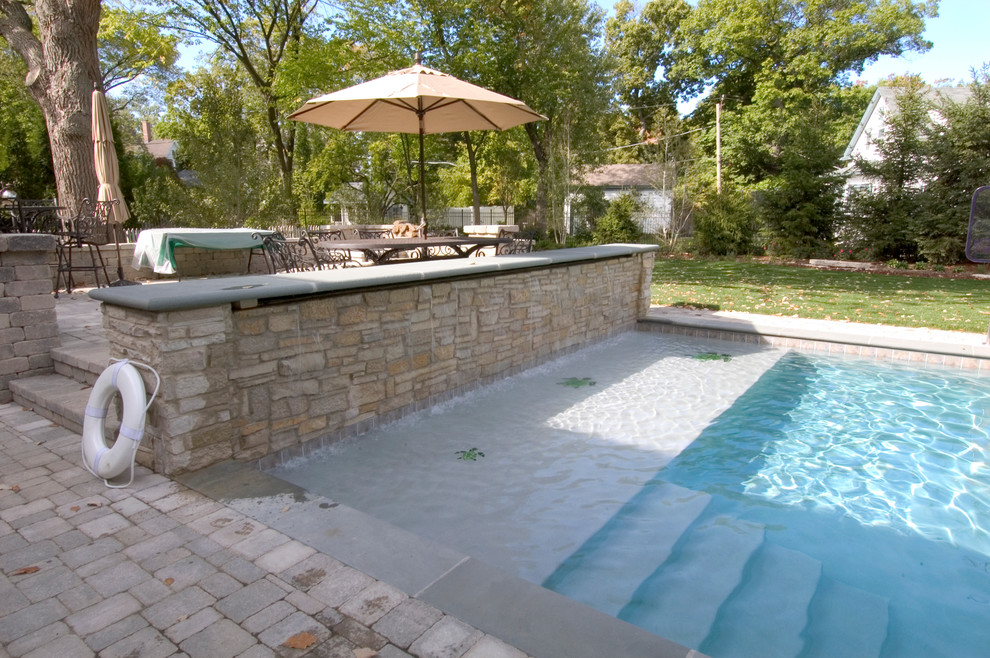 Ispirazione per una piscina monocorsia chic rettangolare di medie dimensioni e dietro casa con pavimentazioni in cemento