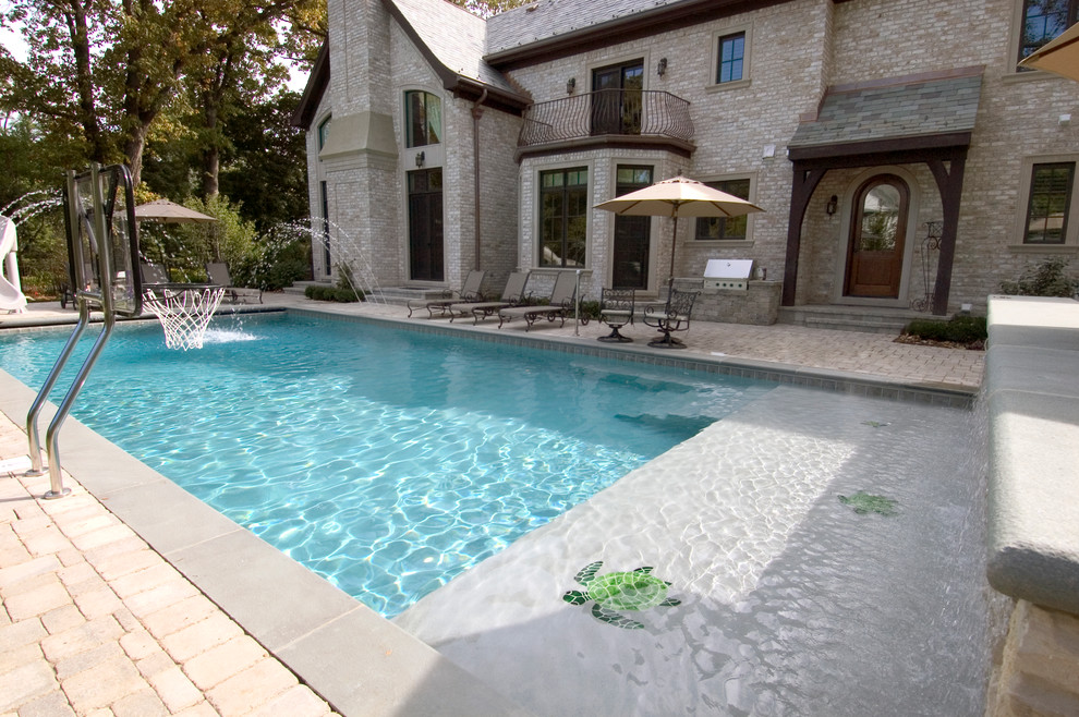 Example of a mid-sized classic backyard concrete paver and rectangular lap pool design in Chicago