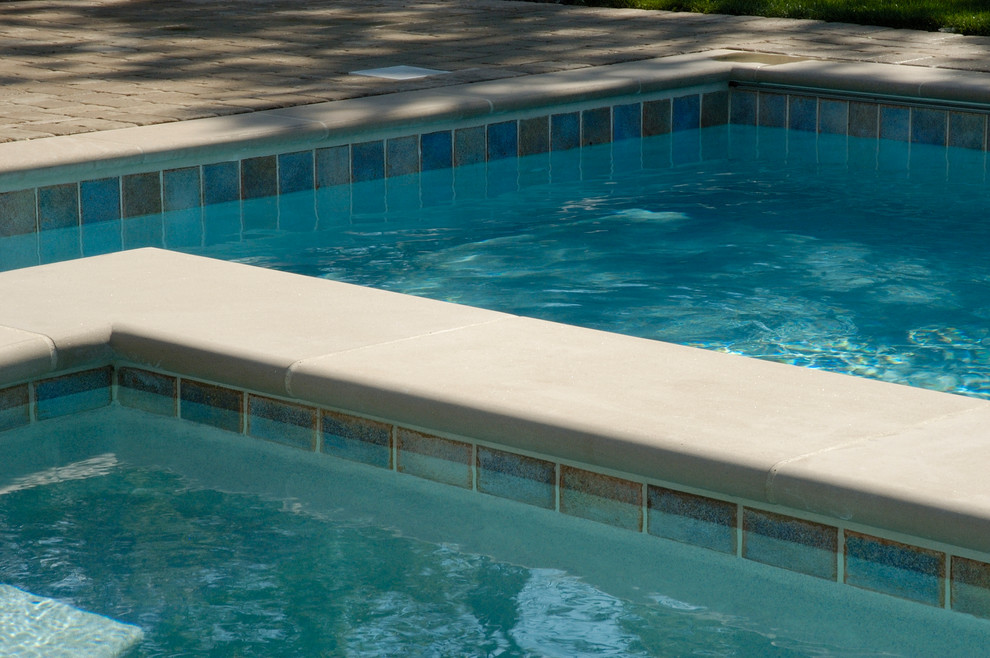 Cette image montre un couloir de nage arrière traditionnel de taille moyenne et rectangle avec des pavés en béton et un bain bouillonnant.