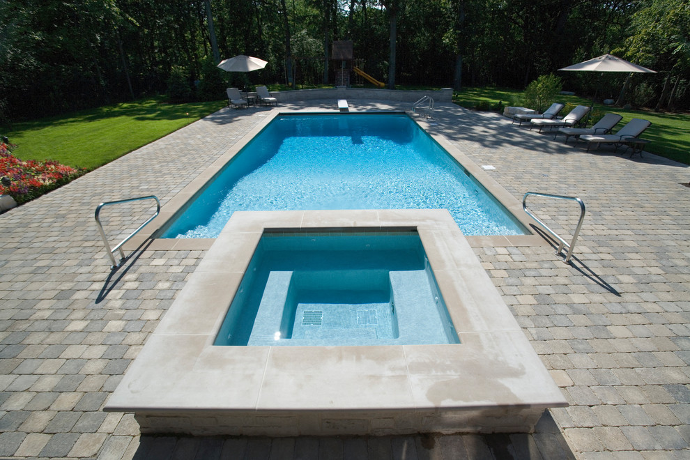 На фото: спортивный, прямоугольный бассейн среднего размера на заднем дворе в классическом стиле с джакузи и мощением клинкерной брусчаткой