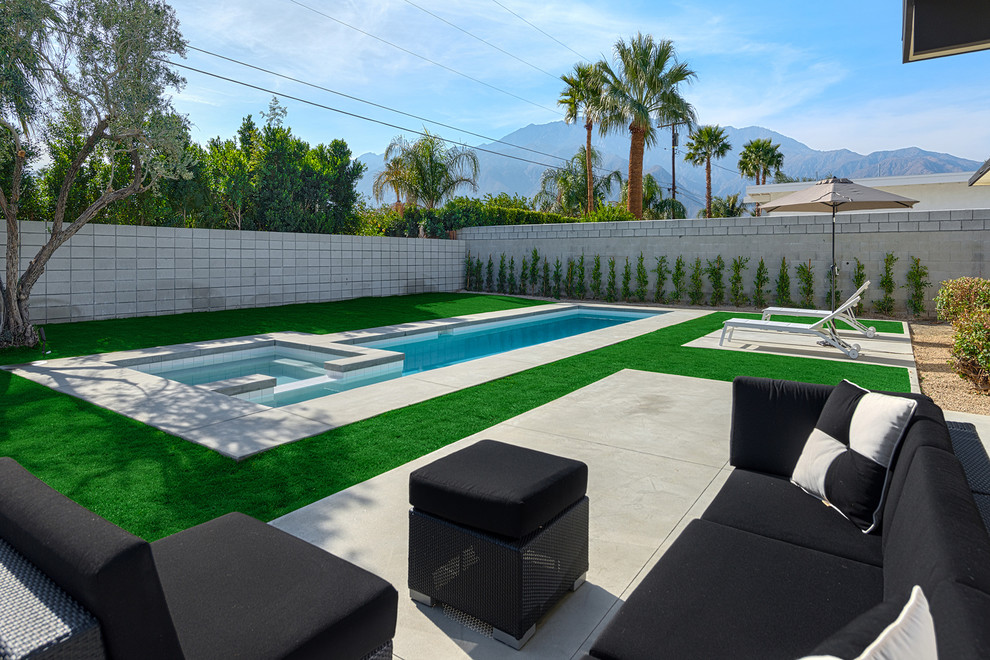 This is an example of a midcentury lengths swimming pool in Los Angeles with fencing.