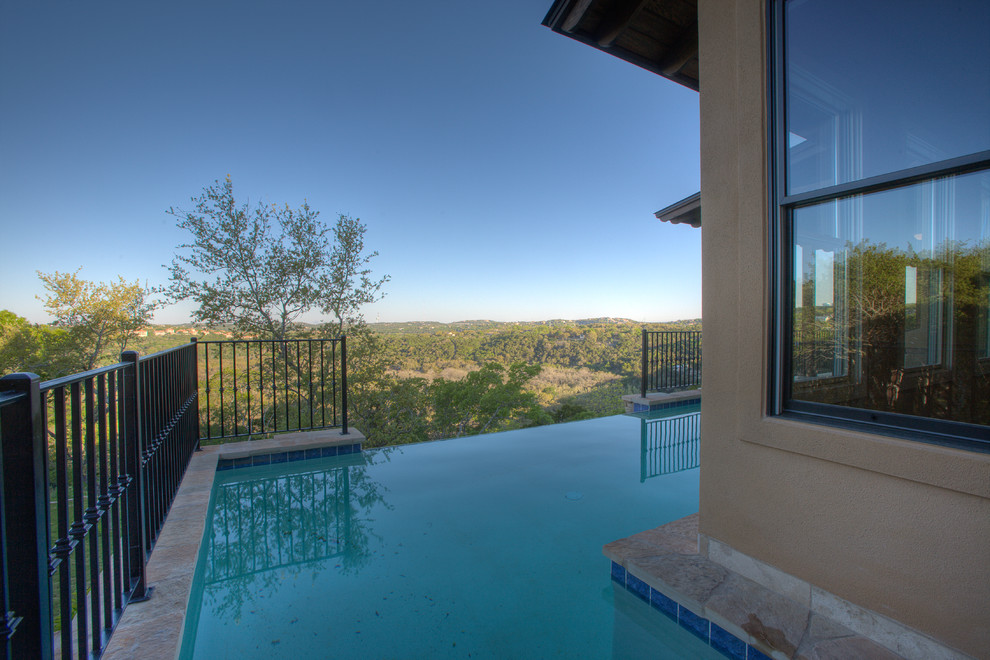 Example of a mid-sized eclectic backyard custom-shaped and stone infinity pool fountain design in Austin
