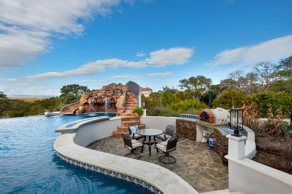 Photo of a mediterranean custom shaped swimming pool in Austin with a water slide.