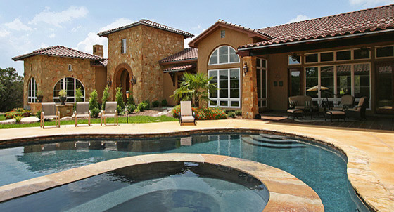 Photo of a medium sized mediterranean back custom shaped natural hot tub in Austin with stamped concrete.