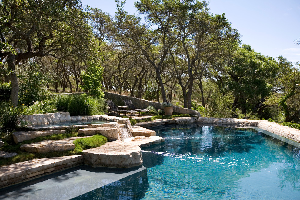 Foto di una piscina chic personalizzata dietro casa con pavimentazioni in pietra naturale