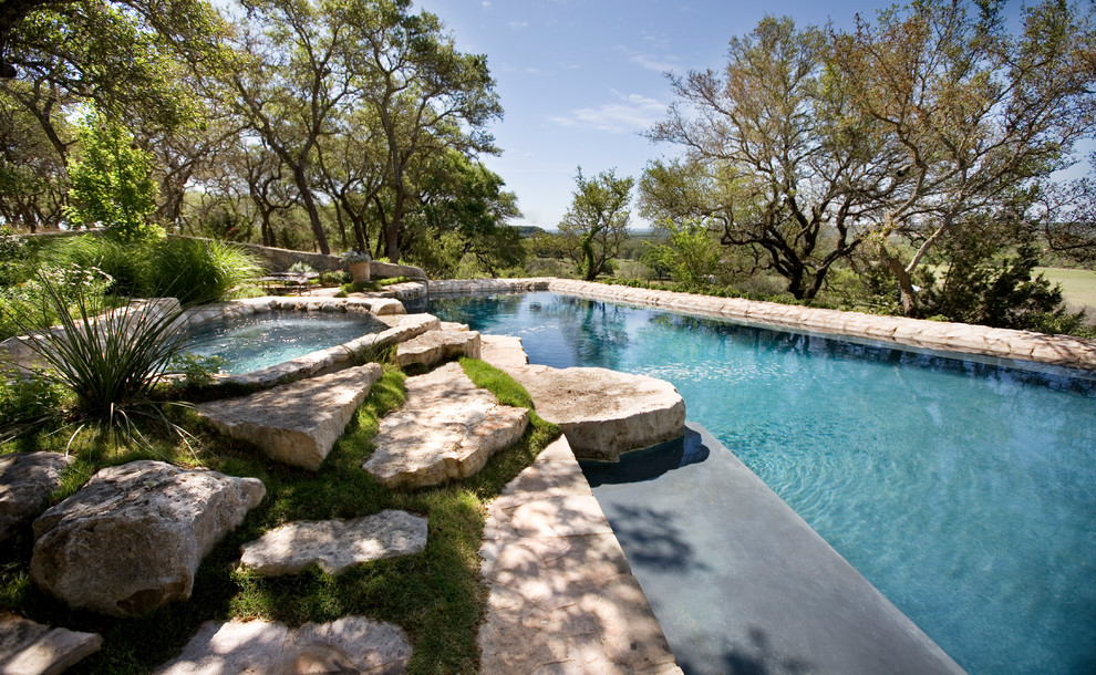 Imagen de piscina rústica a medida en patio trasero con adoquines de piedra natural