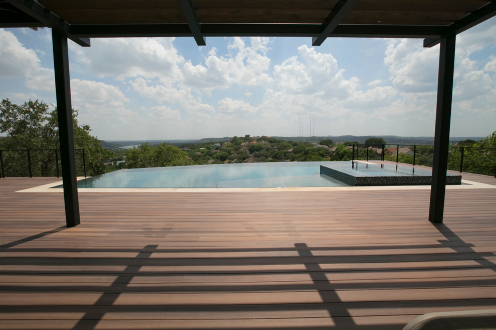 Foto di una grande piscina a sfioro infinito design rettangolare dietro casa con una vasca idromassaggio e pedane