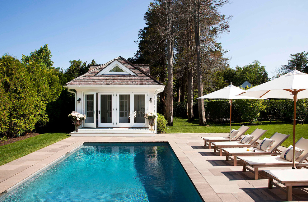 Diseño de casa de la piscina y piscina alargada costera grande rectangular en patio trasero con suelo de hormigón estampado