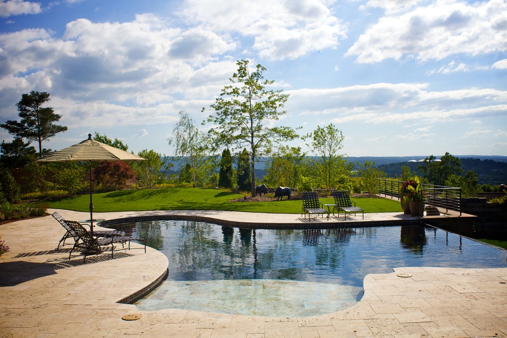 Example of a large classic front yard stone and custom-shaped infinity pool house design in New York