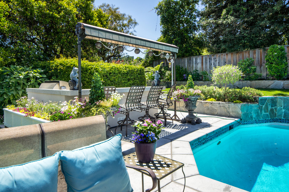 Immagine di una piscina naturale classica personalizzata di medie dimensioni e dietro casa con pavimentazioni in cemento