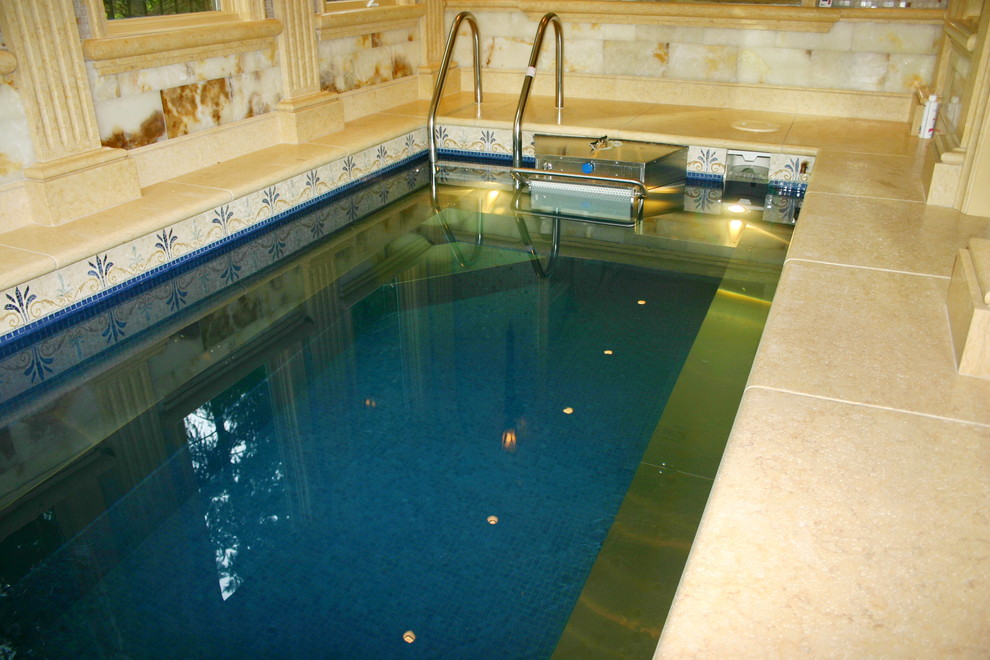 Esempio di un'ampia piscina coperta mediterranea rettangolare con pavimentazioni in pietra naturale