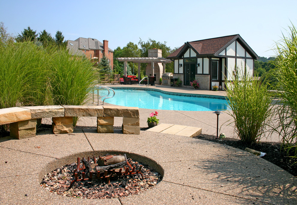 Exempel på en stor modern anpassad pool på baksidan av huset, med betongplatta