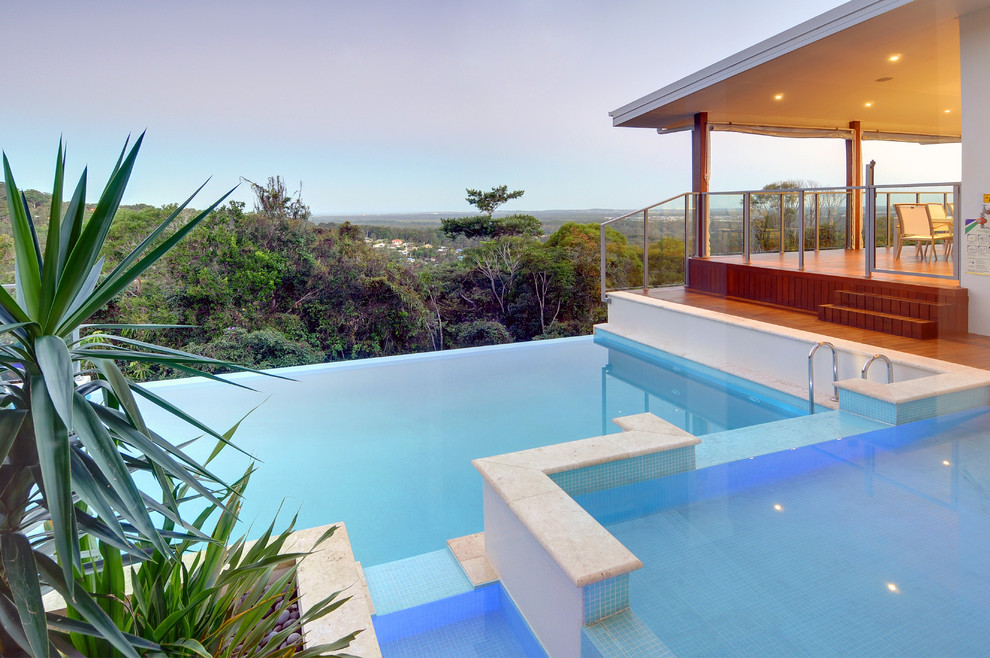 Inspiration for a medium sized contemporary custom shaped infinity swimming pool in Sunshine Coast with a water feature and tiled flooring.