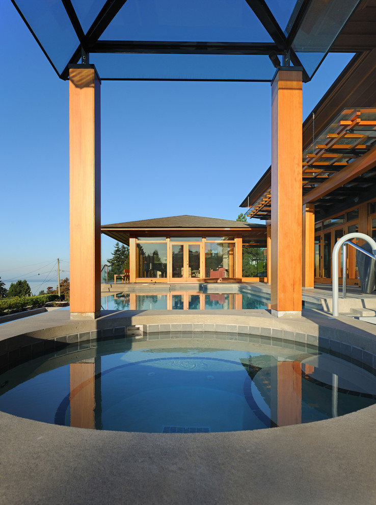 Foto de piscina infinita contemporánea grande rectangular en patio trasero
