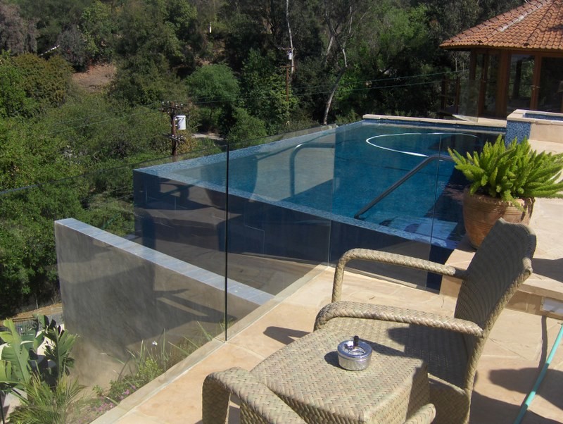 Foto di una piscina a sfioro infinito minimal personalizzata di medie dimensioni e dietro casa con una vasca idromassaggio e cemento stampato