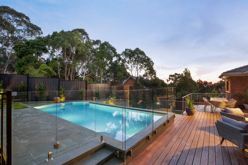 Foto de piscina alargada clásica renovada grande a medida en patio trasero con entablado