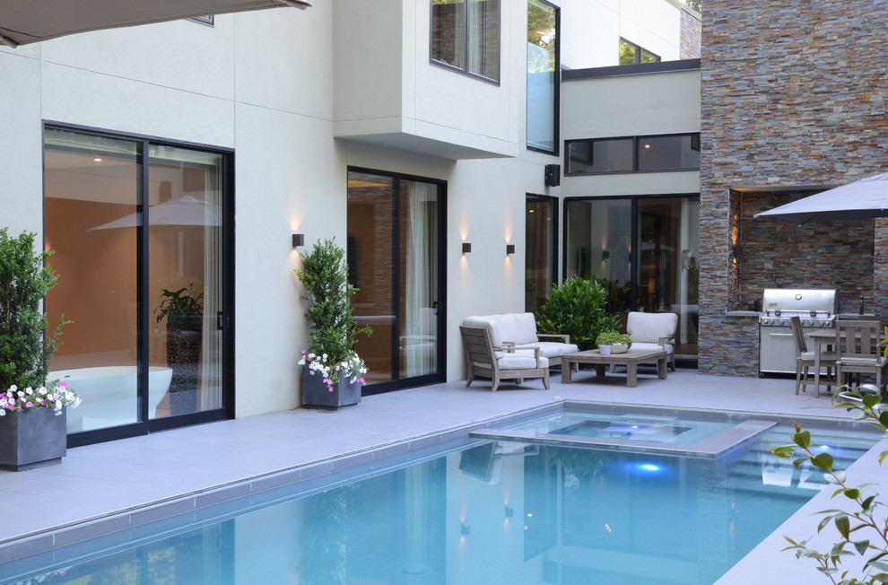 Idées déco pour une grande piscine sur toit naturelle moderne rectangle avec un bain bouillonnant et du carrelage.