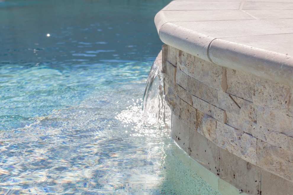 Idee per una grande piscina design personalizzata dietro casa con fontane e piastrelle