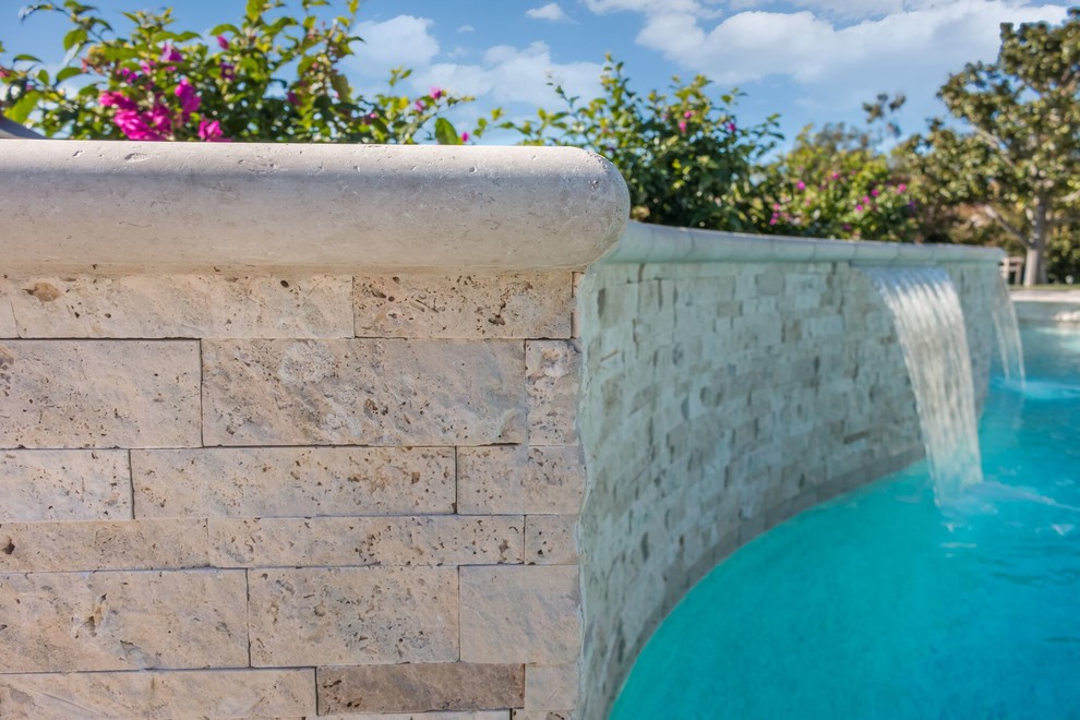Immagine di una grande piscina minimal personalizzata dietro casa con fontane e piastrelle
