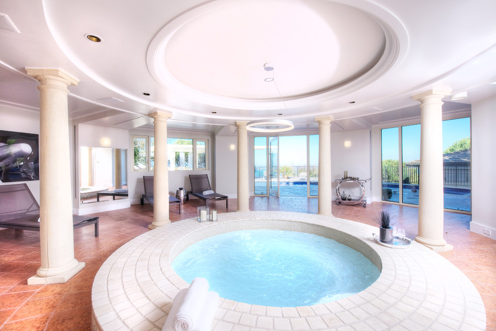 Diseño de casa de la piscina y piscina mediterránea extra grande redondeada y interior con suelo de baldosas