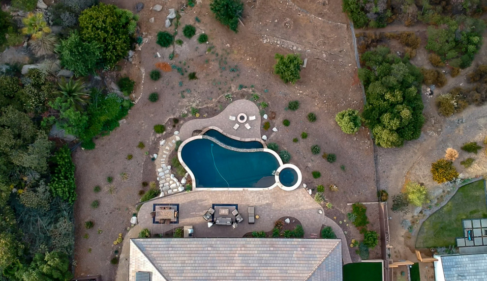 Esempio di una piscina a sfioro infinito mediterranea personalizzata di medie dimensioni e dietro casa con paesaggistica bordo piscina e pavimentazioni in cemento