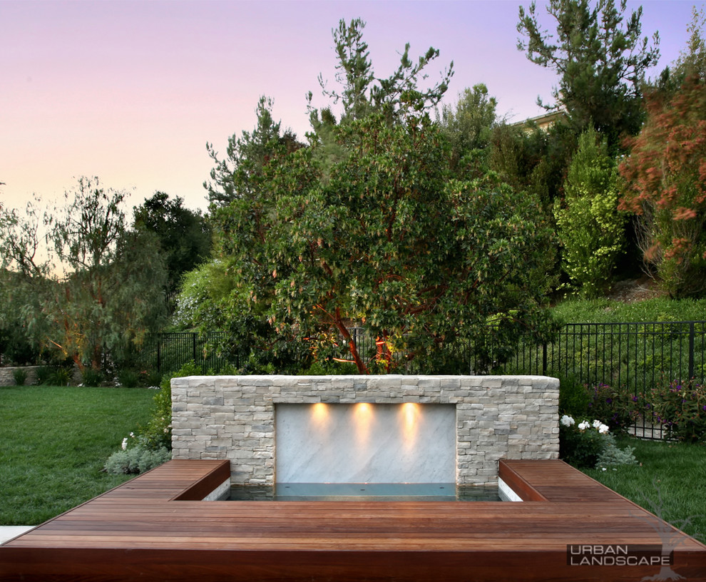 Foto di una piccola piscina monocorsia moderna rettangolare dietro casa con una vasca idromassaggio e pedane