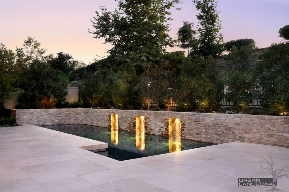 Large minimalist backyard stone and rectangular lap hot tub photo in Orange County
