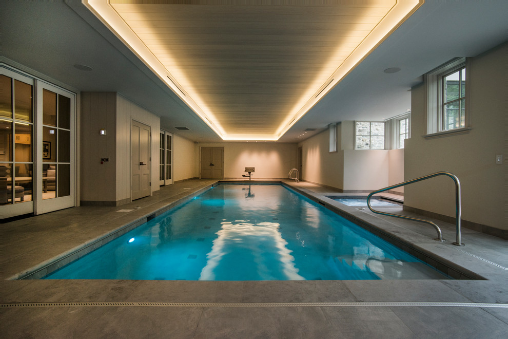 На фото: спортивный, прямоугольный бассейн среднего размера в доме в стиле модернизм с джакузи и покрытием из каменной брусчатки с