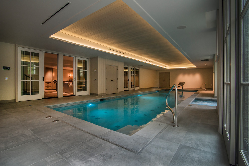 Foto di una piscina coperta monocorsia minimalista rettangolare di medie dimensioni con una vasca idromassaggio e pavimentazioni in pietra naturale