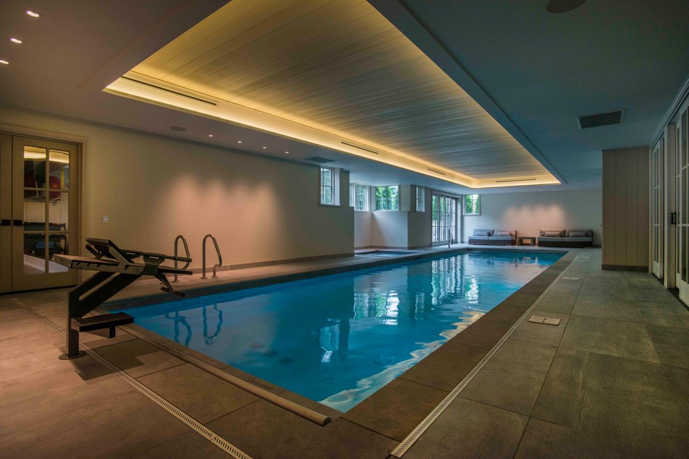 Foto de piscinas y jacuzzis alargados modernos de tamaño medio interiores y rectangulares con adoquines de piedra natural