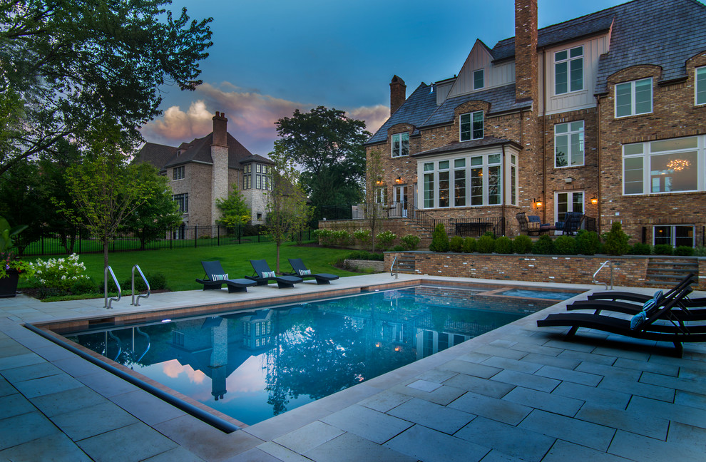 Ispirazione per una piscina monocorsia classica rettangolare di medie dimensioni e dietro casa con una vasca idromassaggio e pavimentazioni in pietra naturale