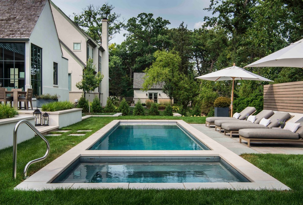 Foto de piscinas y jacuzzis alargados clásicos de tamaño medio rectangulares en patio trasero con adoquines de piedra natural