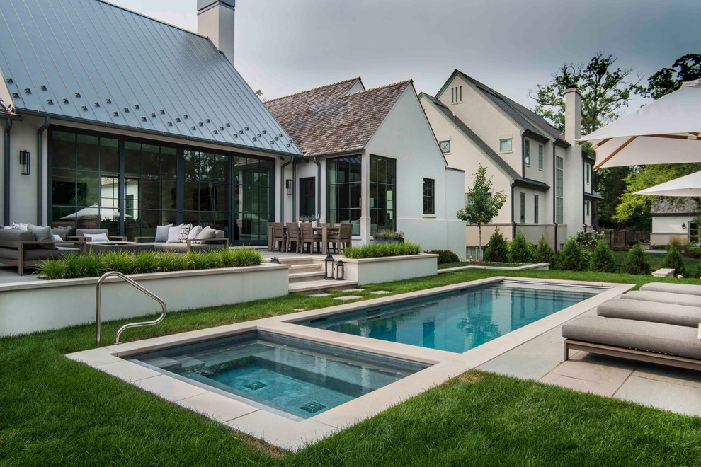Immagine di una piscina monocorsia tradizionale rettangolare di medie dimensioni e dietro casa con una vasca idromassaggio e pavimentazioni in pietra naturale
